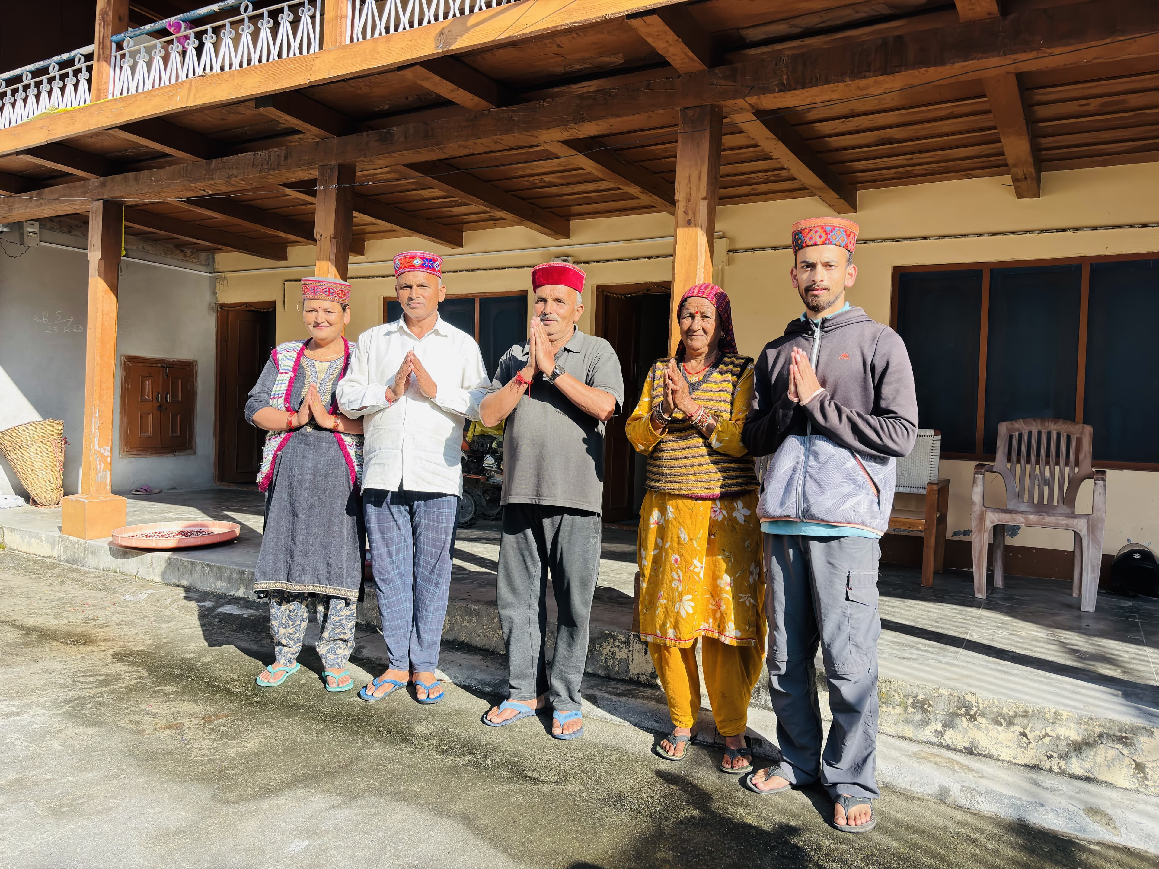 The whole family at Varun Home Stay — Varun with his parents and family elders in traditional Himachali topis